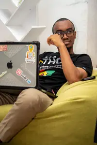 Un étudiant concentré derrière son laptop couvert de stickers